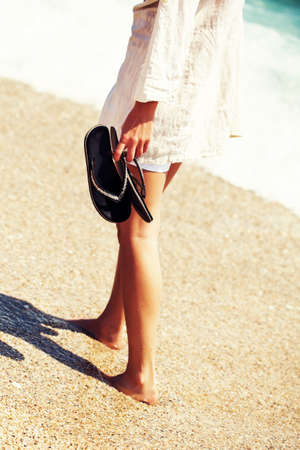 Woman walking on the beach intentionally toned.