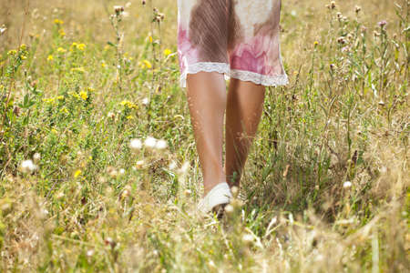 Closeup photo of female legs in the grassの写真素材