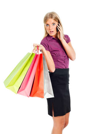 Woman holding shopping bags and talking on phoneの写真素材