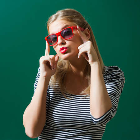 Young girl sending kiss in front of blackboard.の写真素材