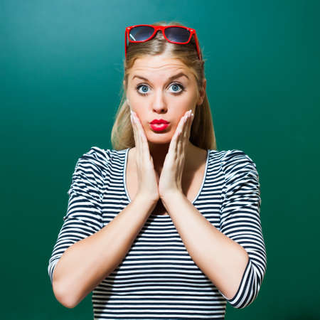 Portrait of surprised student girl in front of blackboard.の写真素材