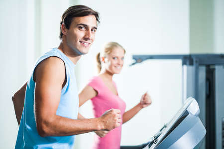 Happy couple exercising in gymの写真素材