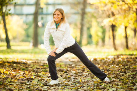 Young happy woman exercising in park