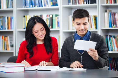 Happy students learning in libraryの写真素材