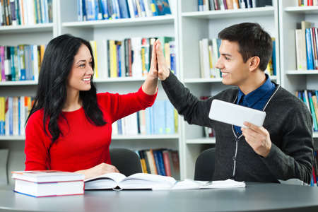 Happy students learning in libraryの写真素材