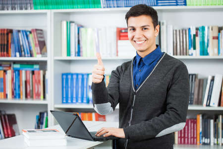 Happy student learning in libraryの写真素材