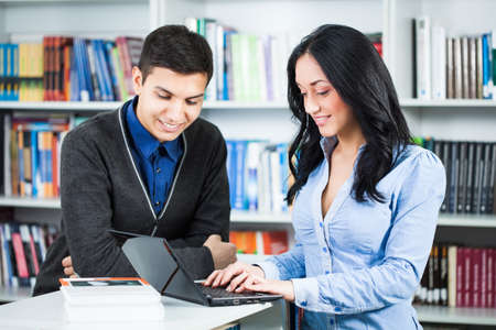 Happy students learning in libraryの写真素材