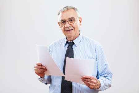 Portrait of successful senior businessman holding documentsの写真素材