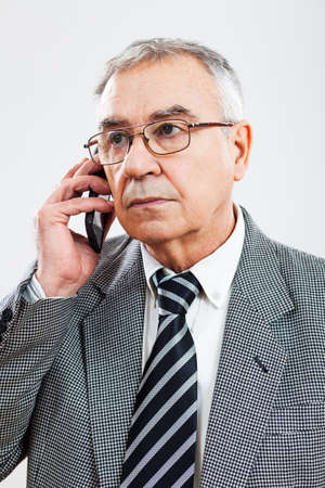 Portrait of senior businessman talking on phoneの写真素材