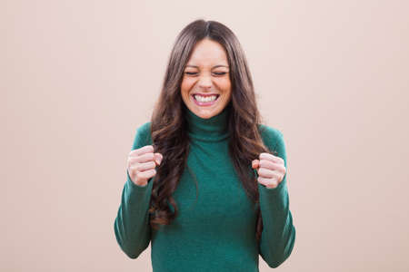 Portrait of happy woman who is hoping for good newsの写真素材
