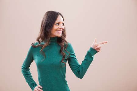 Happy woman pointing at your text or productの写真素材