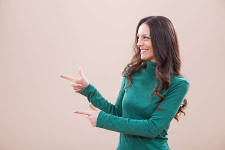 Happy woman pointing at your text or productの写真素材
