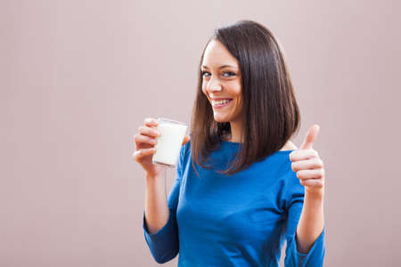 Young woman is drinking milk. Healthy nutrition.の写真素材