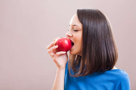 Young woman is eating an apple. Healthy nutrition.の写真素材