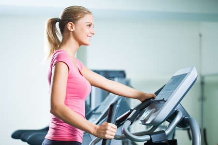 Young woman exercising on treadmill in gym.の写真素材