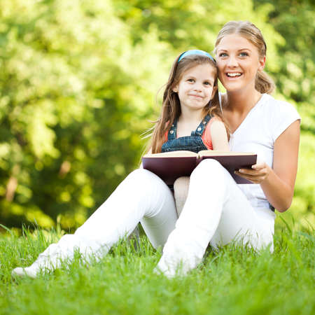 Mother and daughter learning about nature in parkの写真素材