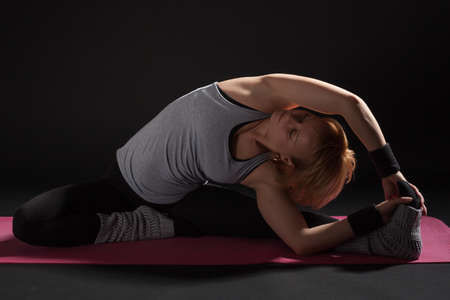 Young woman practicing yoga, Janu Sirsasana / Revolved Head-to-Knee Poseの写真素材