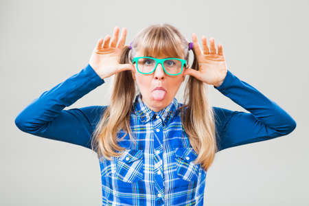 Studio shot portrait of nerdy woman who is making funny faceの写真素材