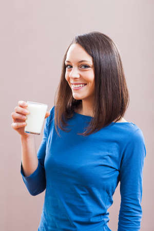 Young woman is drinking milk. Healthy nutrition.の写真素材