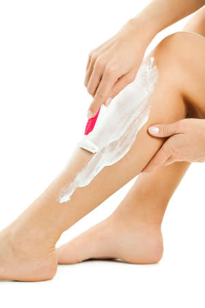 Woman is shaving her legs, isolated on white.の写真素材