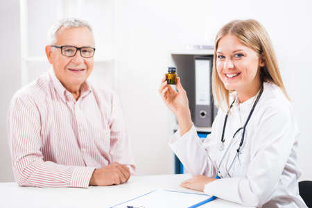 Doctor is telling to her patient about drugs he has to take.の写真素材