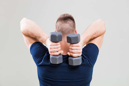 Studio shot image of young man who is exercising with weights.の写真素材