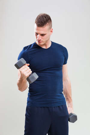 Studio shot image of young man who is exercising with weights.の写真素材