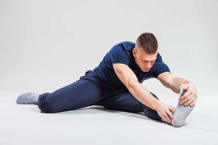 Studio shot image of young man who is stretching his body.の写真素材