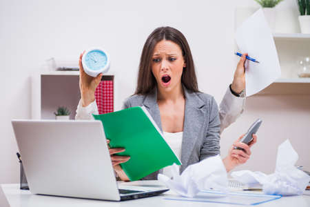 Young businesswoman is angry because she has too much work.の写真素材