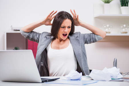 Young businesswoman is angry because she is tired of work.の写真素材