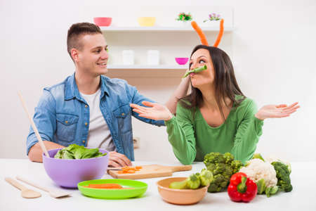 Young couple cooking meal in their kitchen.の写真素材