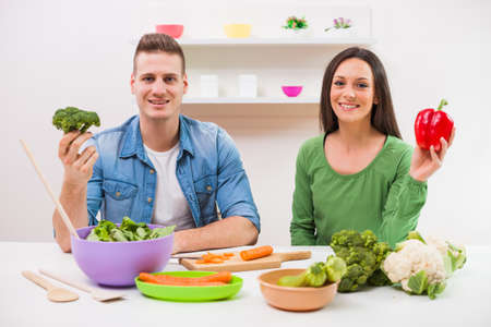 Young couple cooking meal in their kitchen.の写真素材