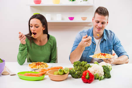 Young couple cooking meal in their kitchen.の写真素材