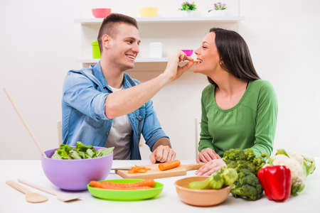 Young couple cooking meal in their kitchen.の写真素材