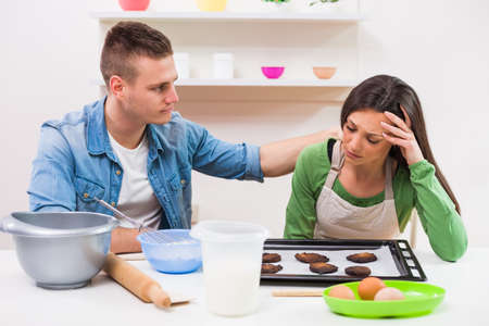 Young couple cooking meal in their kitchen.の写真素材