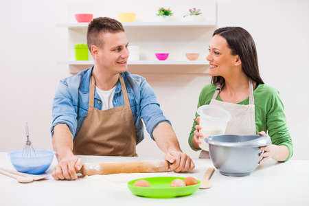 Young couple cooking meal in their kitchen.の写真素材