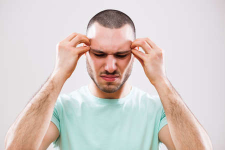Portrait of young man who is having headache.の写真素材