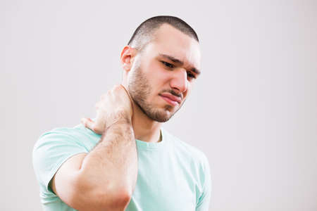Portrait of young man who is having pain in his neck.の写真素材