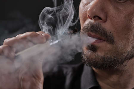 Close up image of man who is smoking electronic cigarette.の写真素材