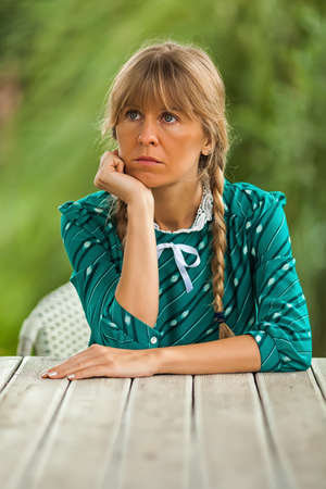 Young woman is sitting at table and thinking.の写真素材