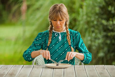 Young woman is having meager meal in times of scarcity.の写真素材