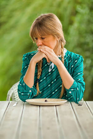 Young woman is having meager meal in times of scarcity.の写真素材