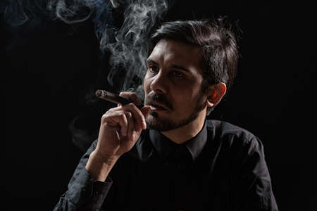 Portrait of adult man who is smoking cigar.の写真素材