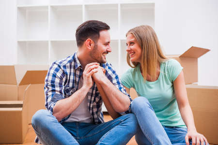 Young couple is moving in their new home. It's time for unpacking.の写真素材