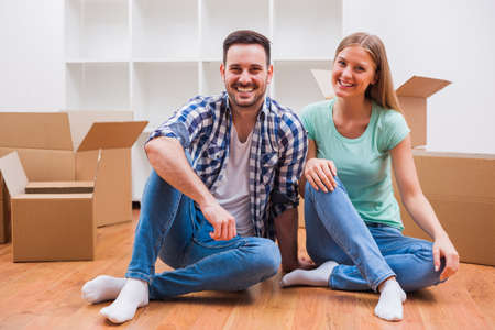 Young couple is moving in their new home. It's time for unpacking.の写真素材