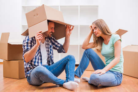 Young couple is moving in their new home. It's time for unpacking.の写真素材
