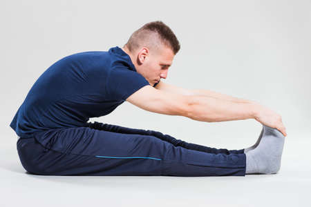 Studio shot image of young man who is stretching his body.の写真素材