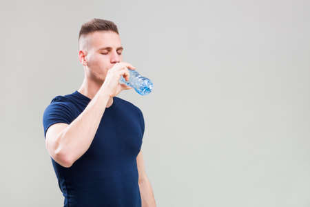 Studio shot image of young sporty man who is drinking water.の写真素材