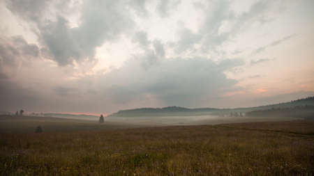 Mountain valley with early morning fog. *Some noise in image because of higher iso settings in camera.の写真素材