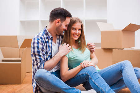 Young couple is moving in their new home. It's time for unpacking.の写真素材